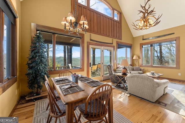 dining room featuring light hardwood / wood-style floors, a high ceiling, and a notable chandelier