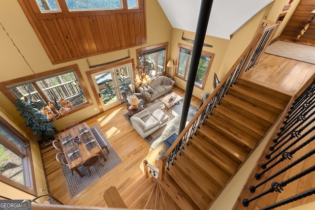 living room featuring a high ceiling, a healthy amount of sunlight, and wood-type flooring