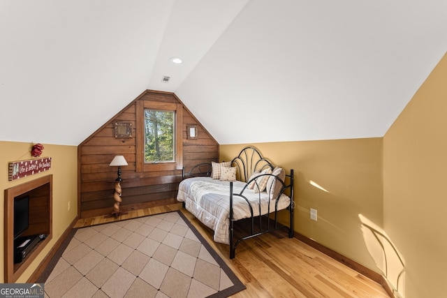 bedroom featuring light wood-type flooring and vaulted ceiling