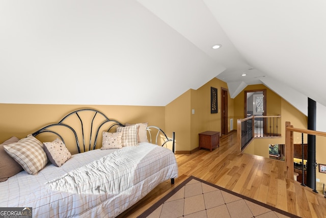 bedroom featuring light hardwood / wood-style floors and lofted ceiling