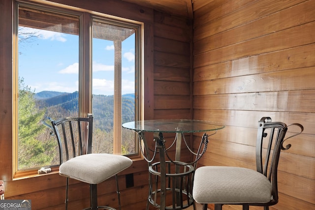 dining area featuring a mountain view and wood walls