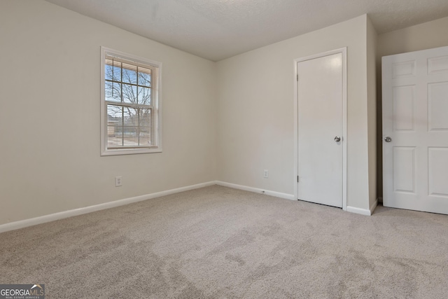 carpeted spare room featuring a textured ceiling