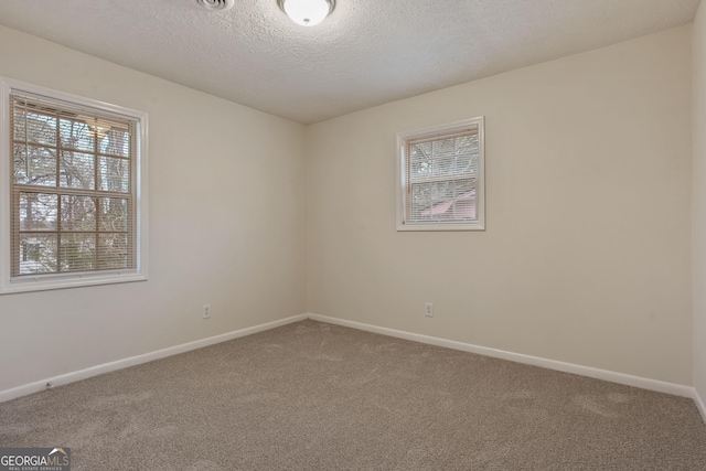 carpeted empty room with a textured ceiling