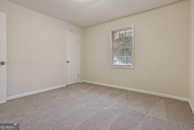 carpeted spare room featuring a textured ceiling