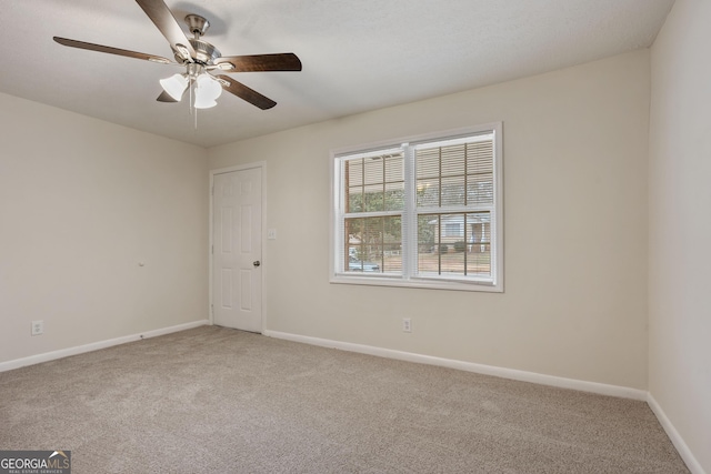 carpeted spare room with ceiling fan