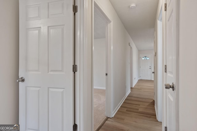 hallway with light hardwood / wood-style floors