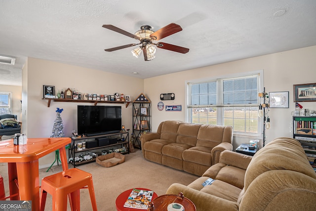 carpeted living room featuring ceiling fan and a textured ceiling