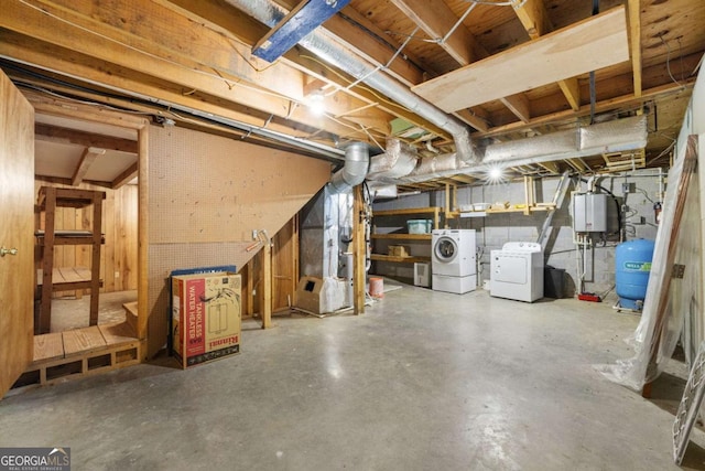 basement featuring washer and clothes dryer and tankless water heater