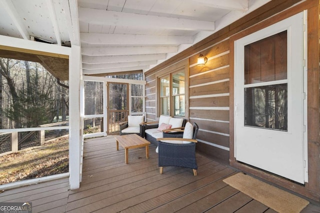 unfurnished sunroom with a healthy amount of sunlight and lofted ceiling with beams