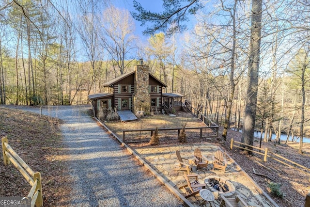 exterior space with an outdoor fire pit and a water view