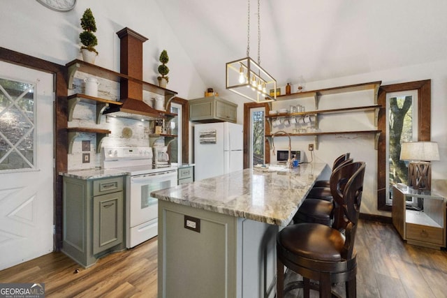 kitchen with light stone countertops, white appliances, dark hardwood / wood-style floors, and hanging light fixtures