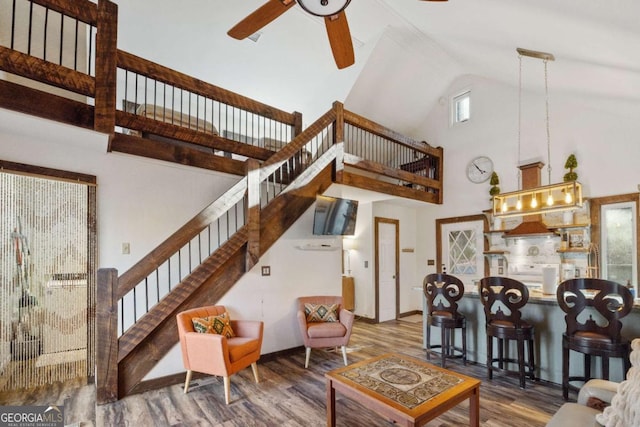 living room featuring hardwood / wood-style flooring, high vaulted ceiling, and ceiling fan