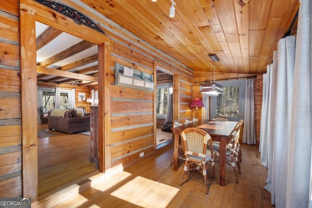 dining space with wood ceiling, light wood-type flooring, wooden walls, and plenty of natural light