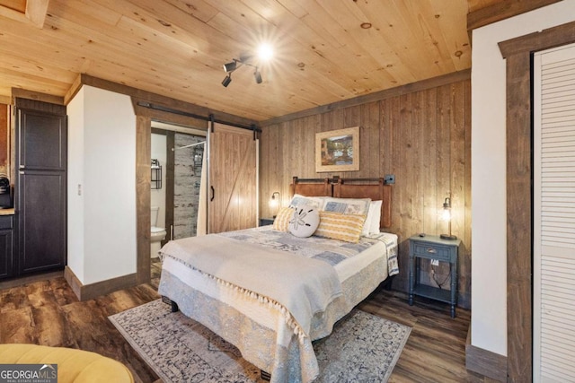 bedroom with ensuite bathroom, dark wood-type flooring, a barn door, wooden ceiling, and wood walls