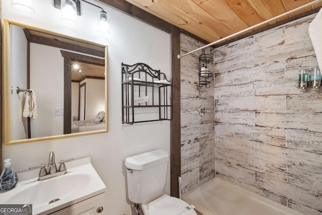 bathroom featuring a tile shower, toilet, vanity, and wood ceiling