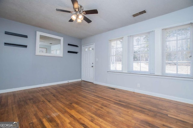 spare room featuring ceiling fan, a textured ceiling, and dark hardwood / wood-style flooring