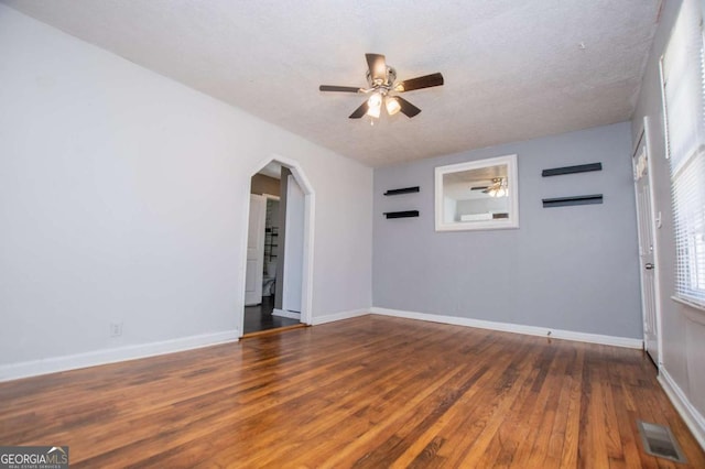 spare room with ceiling fan, a textured ceiling, and dark hardwood / wood-style flooring