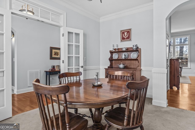 dining space with light colored carpet and ornamental molding