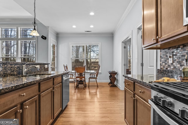 kitchen with decorative light fixtures, sink, backsplash, and dark stone countertops