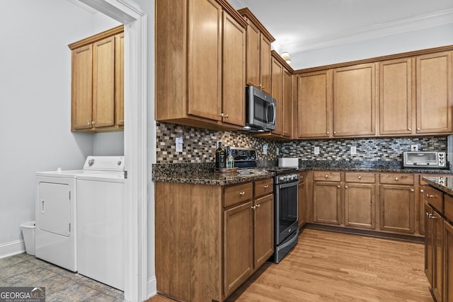 kitchen featuring washer and dryer, appliances with stainless steel finishes, dark stone countertops, backsplash, and ornamental molding