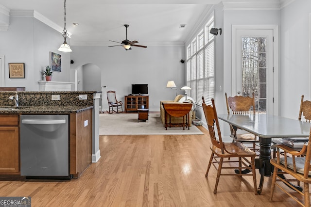 dining room featuring crown molding, light wood-type flooring, sink, and ceiling fan