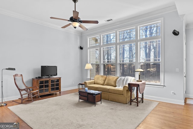 living room featuring hardwood / wood-style floors, ceiling fan, and ornamental molding