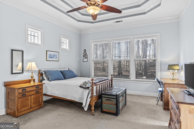 carpeted bedroom with ornamental molding, ceiling fan, and a raised ceiling