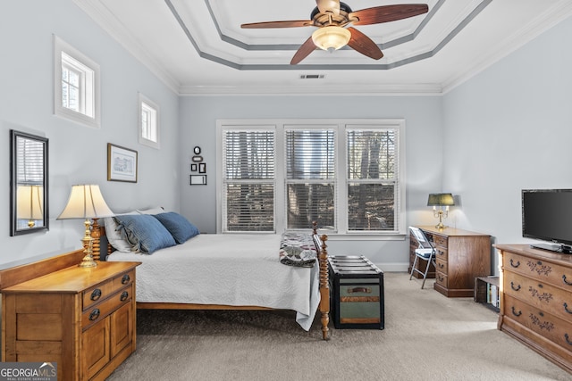 bedroom with ceiling fan, light colored carpet, ornamental molding, and a tray ceiling