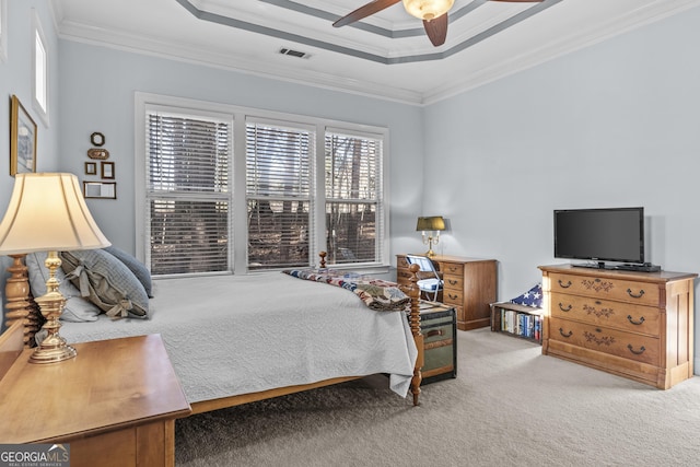 bedroom with ceiling fan, carpet flooring, crown molding, and a raised ceiling