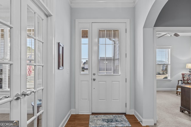 carpeted entryway featuring ornamental molding