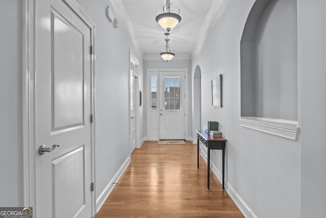 doorway with crown molding and wood-type flooring