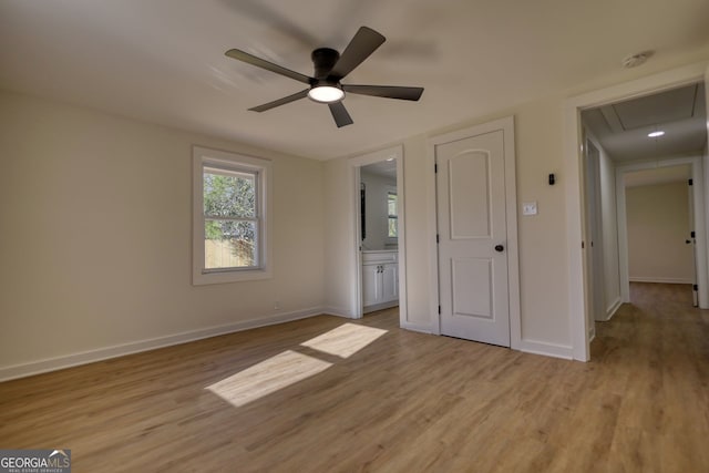 unfurnished bedroom featuring attic access, baseboards, and light wood-type flooring