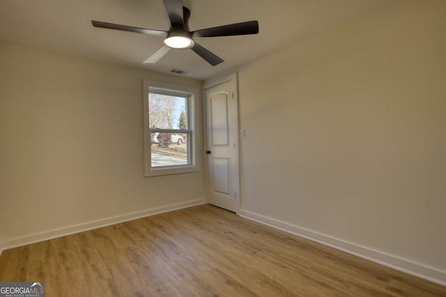 empty room with ceiling fan, light wood-style floors, visible vents, and baseboards