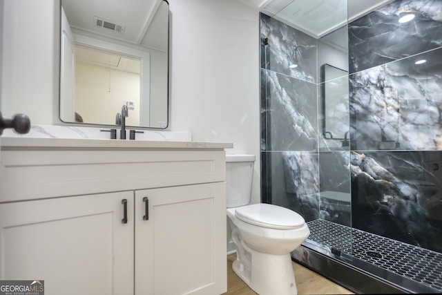 bathroom featuring vanity, toilet, visible vents, and a stall shower