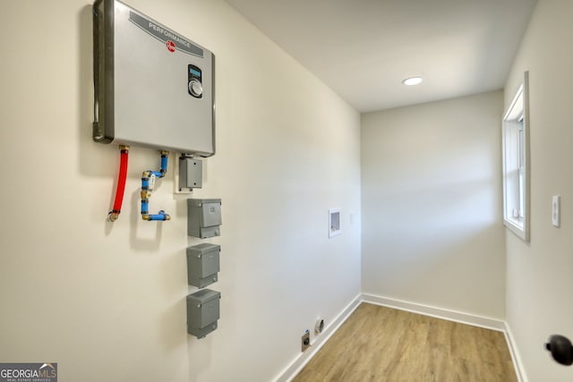 washroom featuring water heater, laundry area, hookup for a washing machine, and baseboards