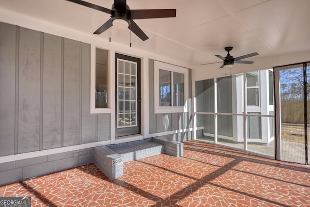 unfurnished sunroom featuring a ceiling fan