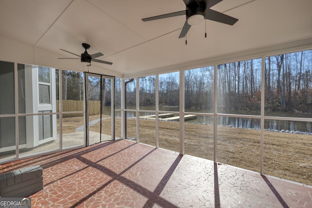 unfurnished sunroom with a healthy amount of sunlight, ceiling fan, and a water view