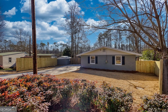 view of home's exterior with an outbuilding and fence