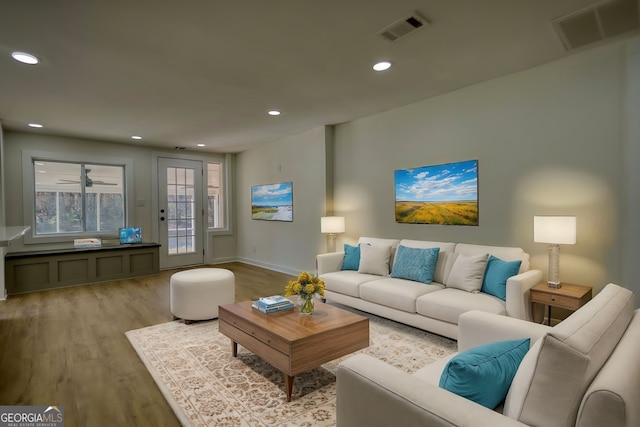 living area with visible vents, recessed lighting, baseboards, and wood finished floors