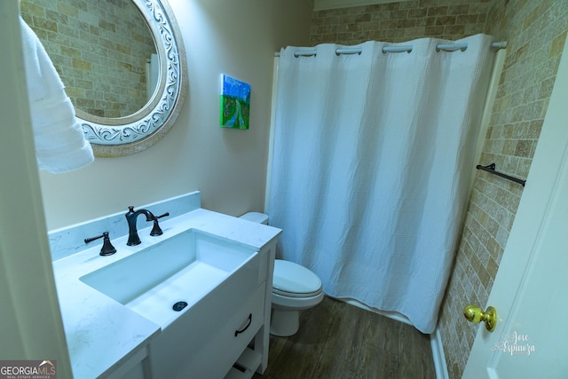 bathroom with hardwood / wood-style flooring, toilet, vanity, and walk in shower