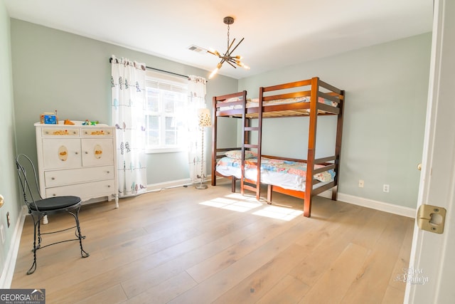 bedroom with an inviting chandelier and light hardwood / wood-style floors