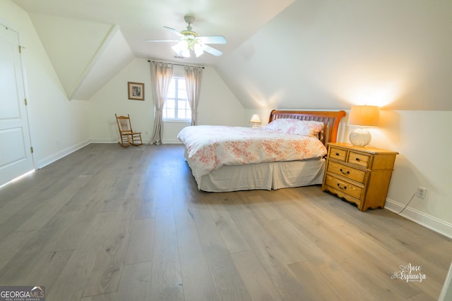 bedroom with ceiling fan, lofted ceiling, and light hardwood / wood-style flooring