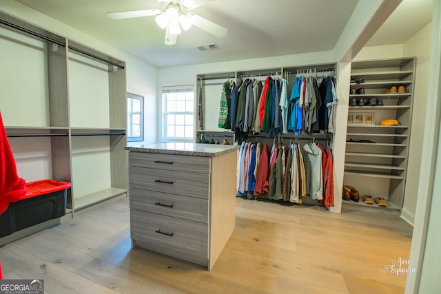 spacious closet with ceiling fan and light wood-type flooring