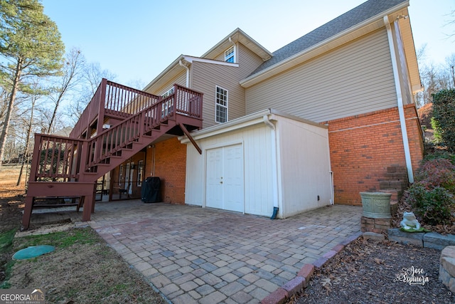 back of property featuring a patio and a wooden deck