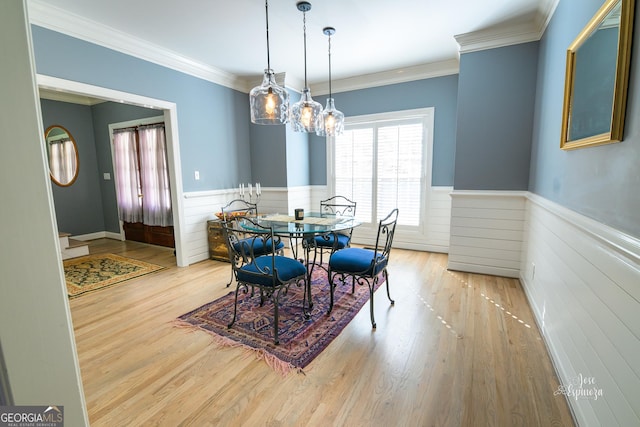 dining area featuring ornamental molding and light wood-type flooring