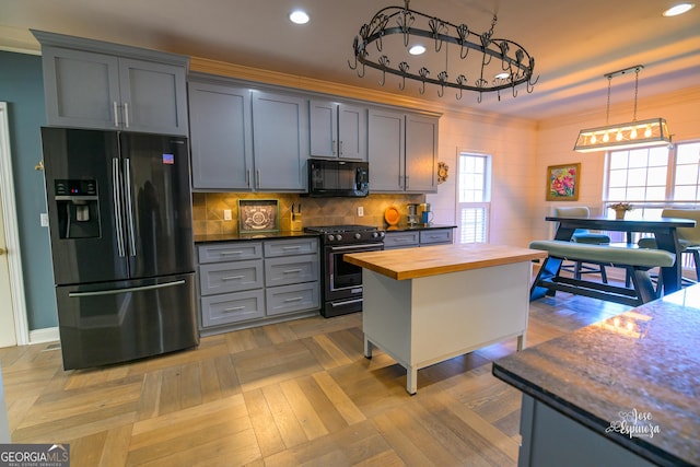 kitchen featuring pendant lighting, range with gas stovetop, wood counters, crown molding, and fridge with ice dispenser