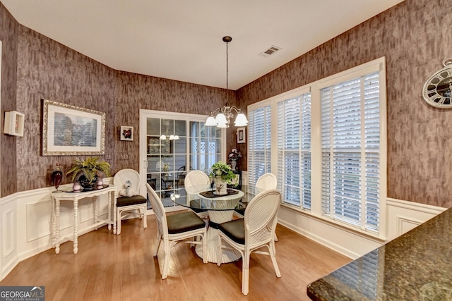 dining space featuring hardwood / wood-style flooring and a notable chandelier