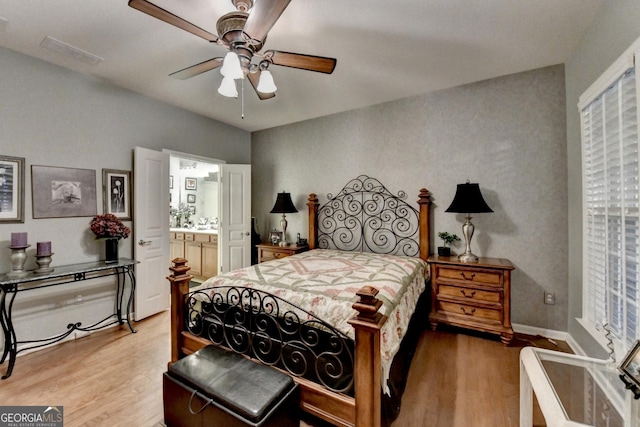 bedroom with ceiling fan, light hardwood / wood-style floors, and ensuite bath