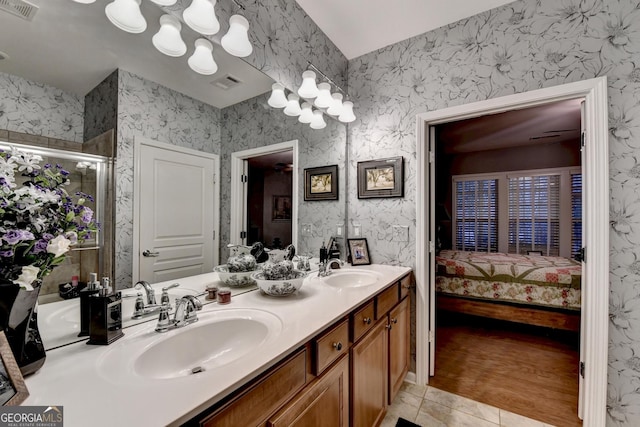 bathroom with walk in shower, vanity, and tile patterned flooring