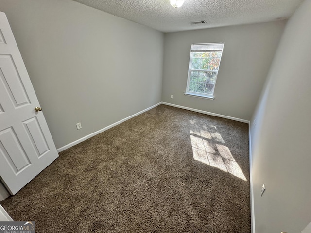 spare room with a textured ceiling and carpet